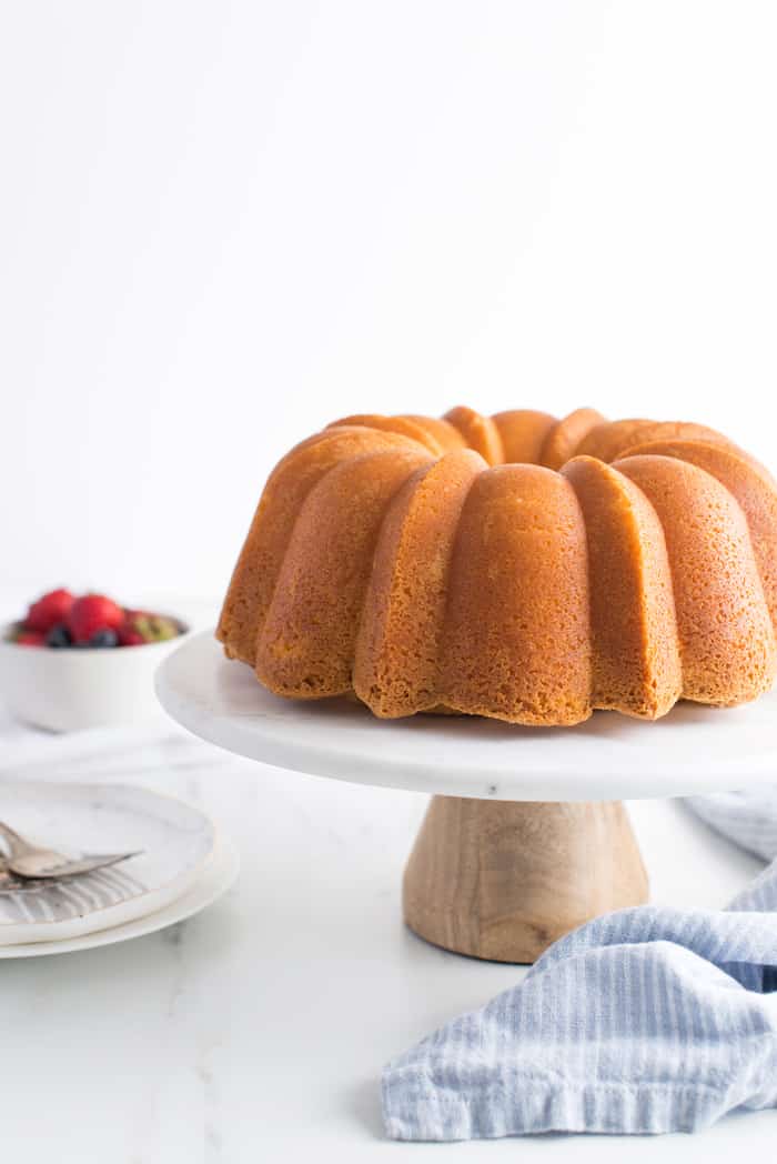 A bundt cake that used homemade cake release on a white cake stand after being baked