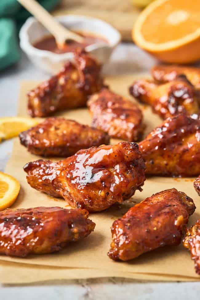 Close up shots of wings with honey orange bbq sauce on them ready to enjoy