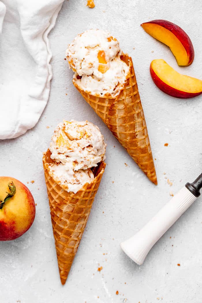 Two cones filled with no churn peach ice cream ready to serve