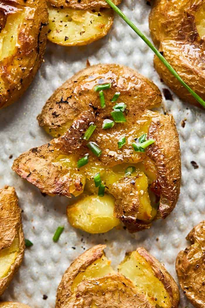 A close up on a garlic butter smashed potato ready to enjoy