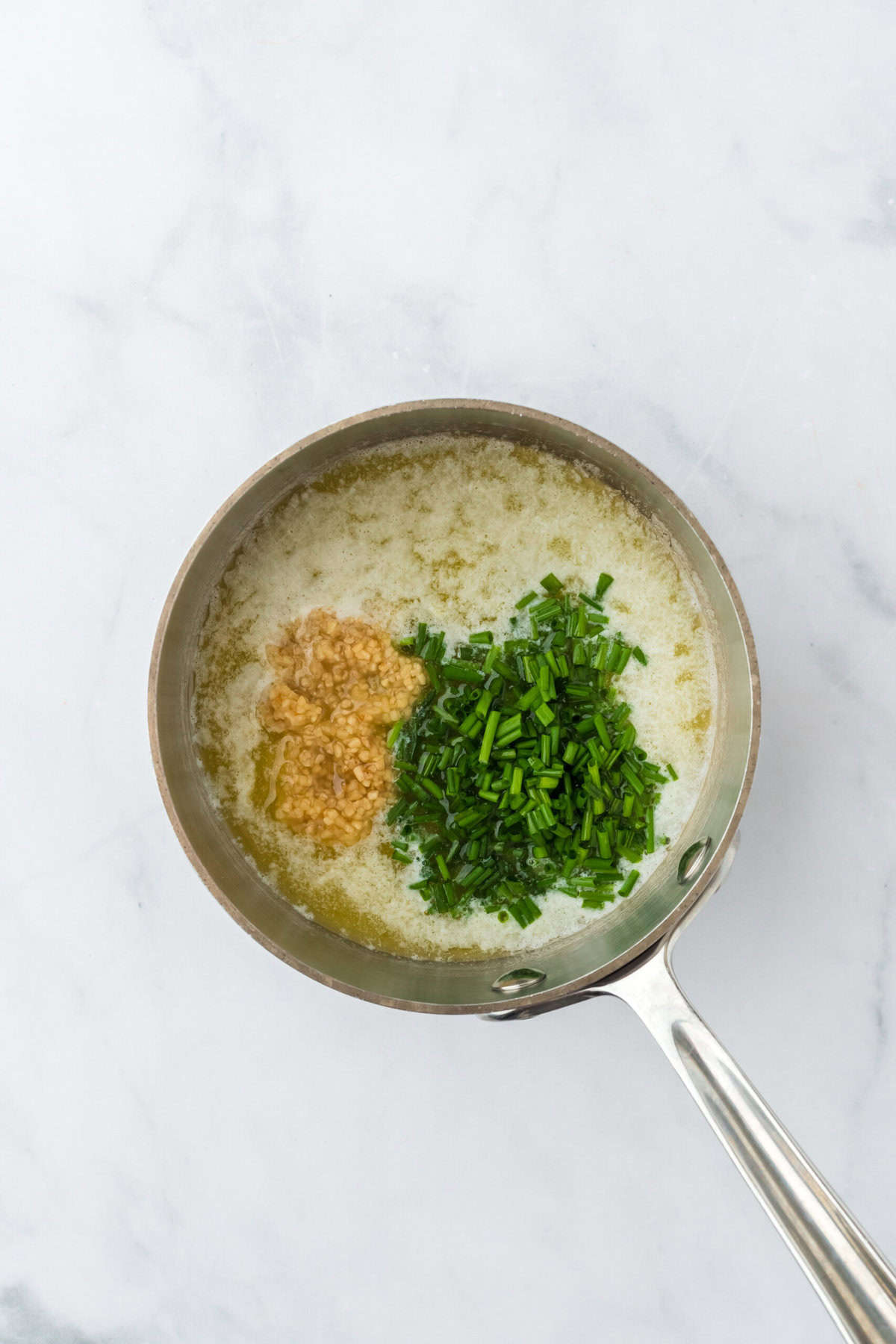 Chives and garlic in melted butter in a saucepan