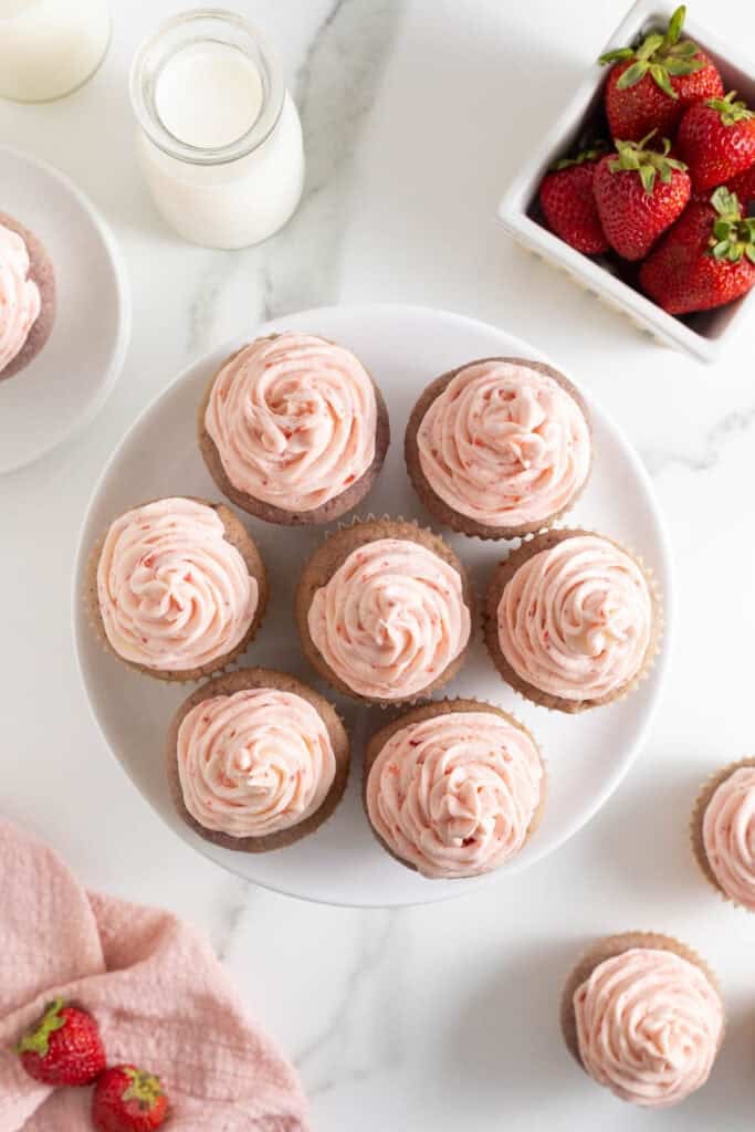 Frosted strawberry cupcakes with strawberry buttercream on a plate