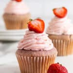 A close up of strawberry cupcakes on white plates