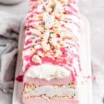 A pink animal cookie icebox cake with pink ganache dripping down sides
