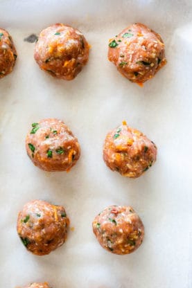 Turkey meatballs formed on parchment paper before cooking