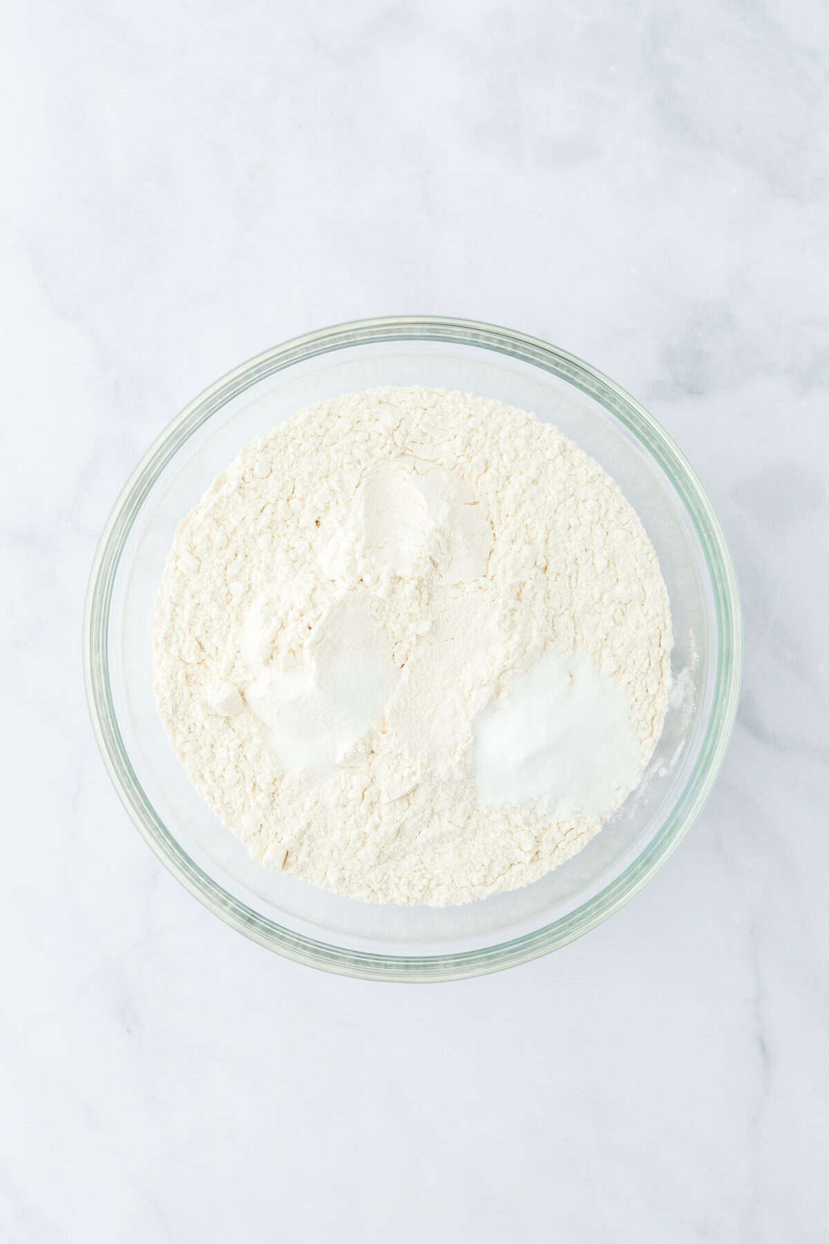 Dry ingredients in a glass bowl on a white countertop