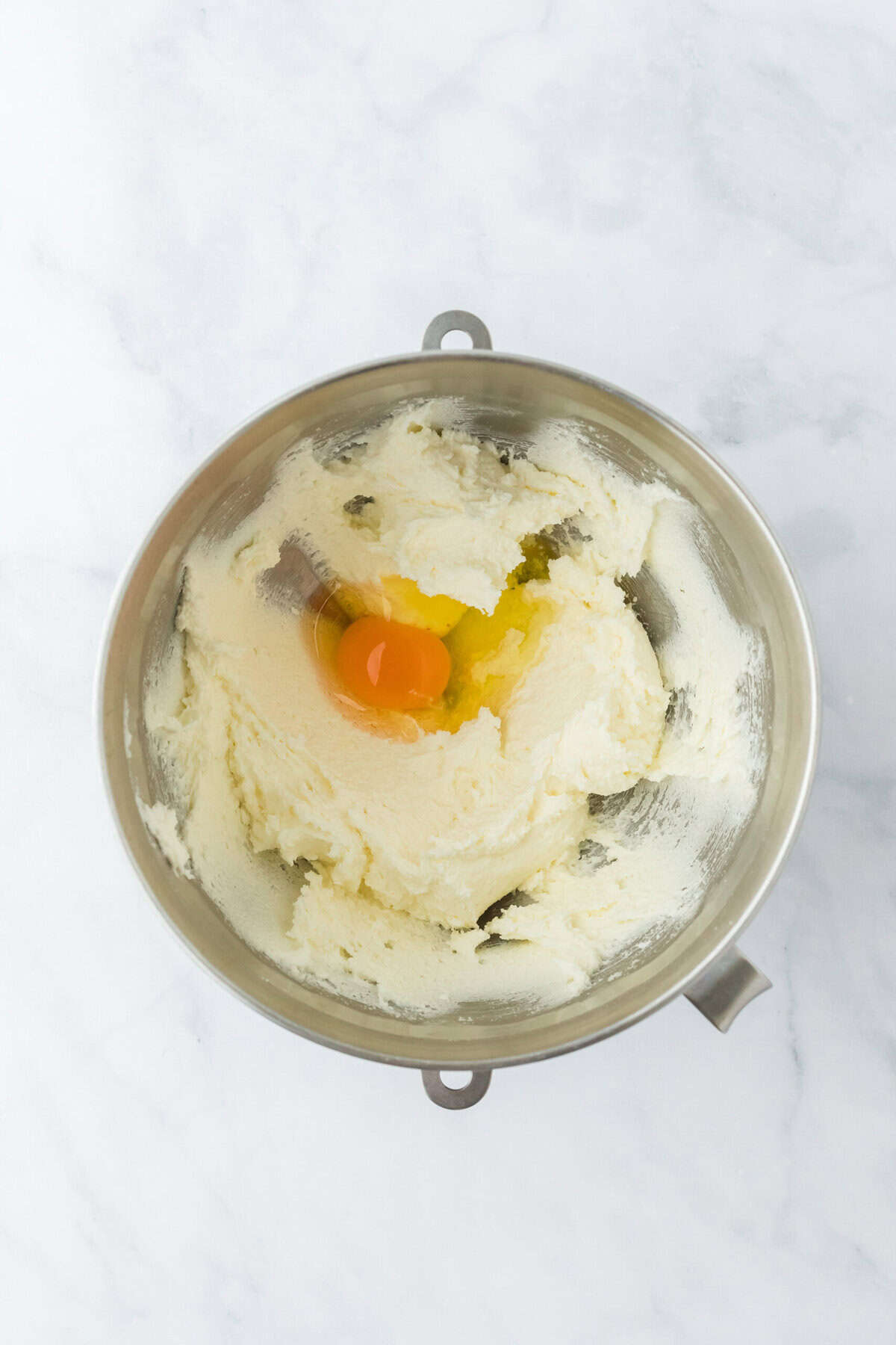 Eggs added to simple banana cake recipe batter in stand mixer bowl