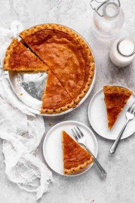 a classic chess pie with slices cut out of the whole served on white plates
