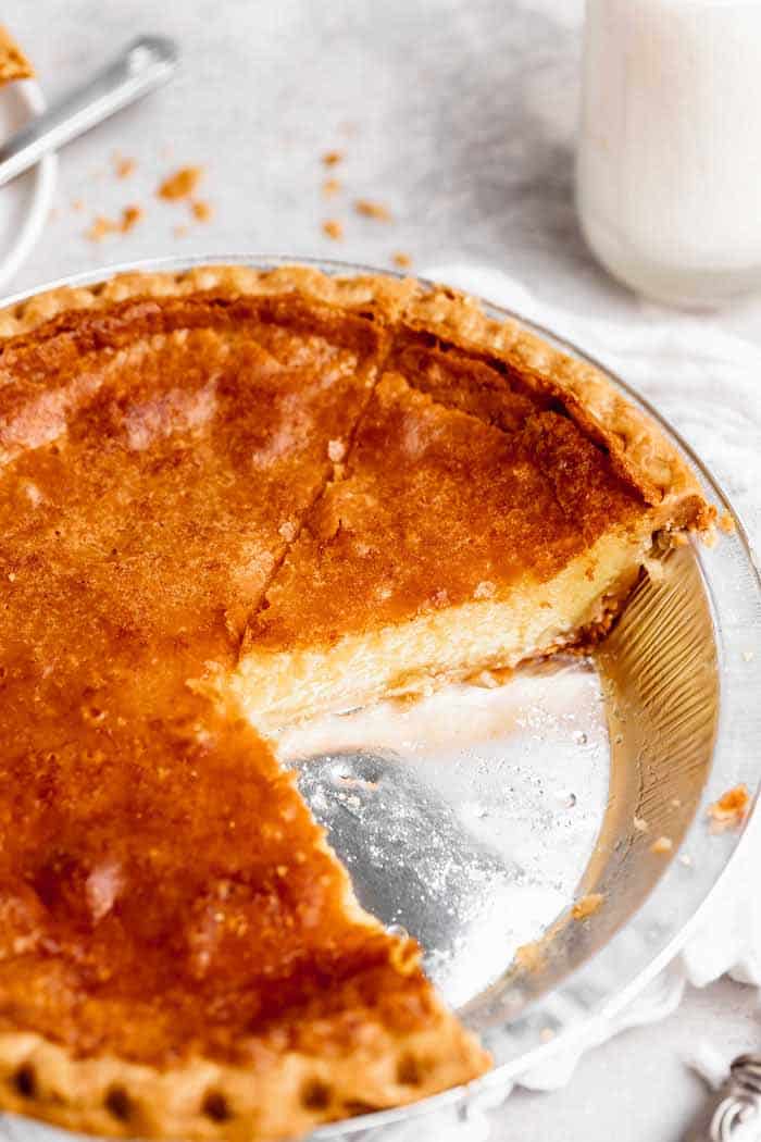 A close up of southern chess pie with slice missing with custard filling showing