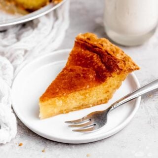 A slice of Southern custard pie sitting on a white plate with a silver fork