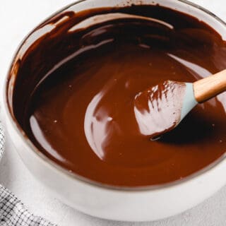 A spatula stirring a smooth chocolate ganache