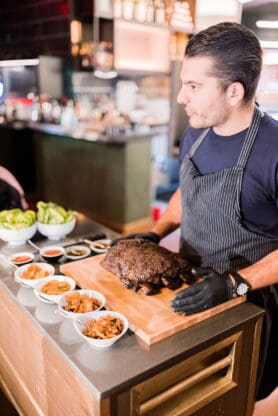 Head chef at Majordomo cutting short ribs