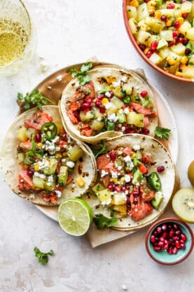 Three fish tacos made with salmon on a round plate ready to serve