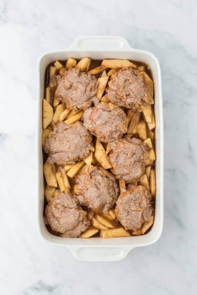 Easy apple cobbler recipe in a white baking dish on a white background before baking