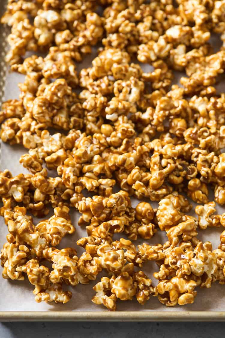 Caramel corn on a baking sheet just after being roasted in an oven for an hour