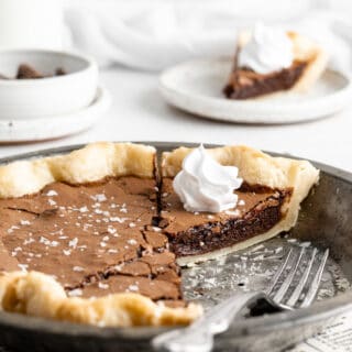 A close up of inside of a chocolate chess pie recipe with whipped cream on a slice