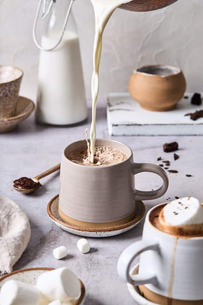 Cream being poured into a glass mug to serve
