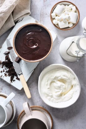 A decadent chocolate along with cream and ingredients to make french hot cocoa