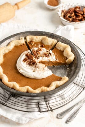 A close up of classic pumpkin pie with a slice missing showing the texture