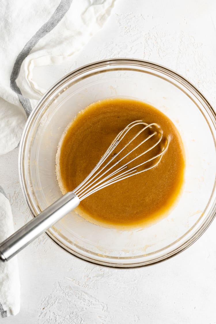 Brown butter in a clear bowl with a whisk