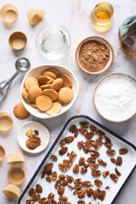 An overhead of ingredients including toasted pecans, nilla wafers, coca powder and more