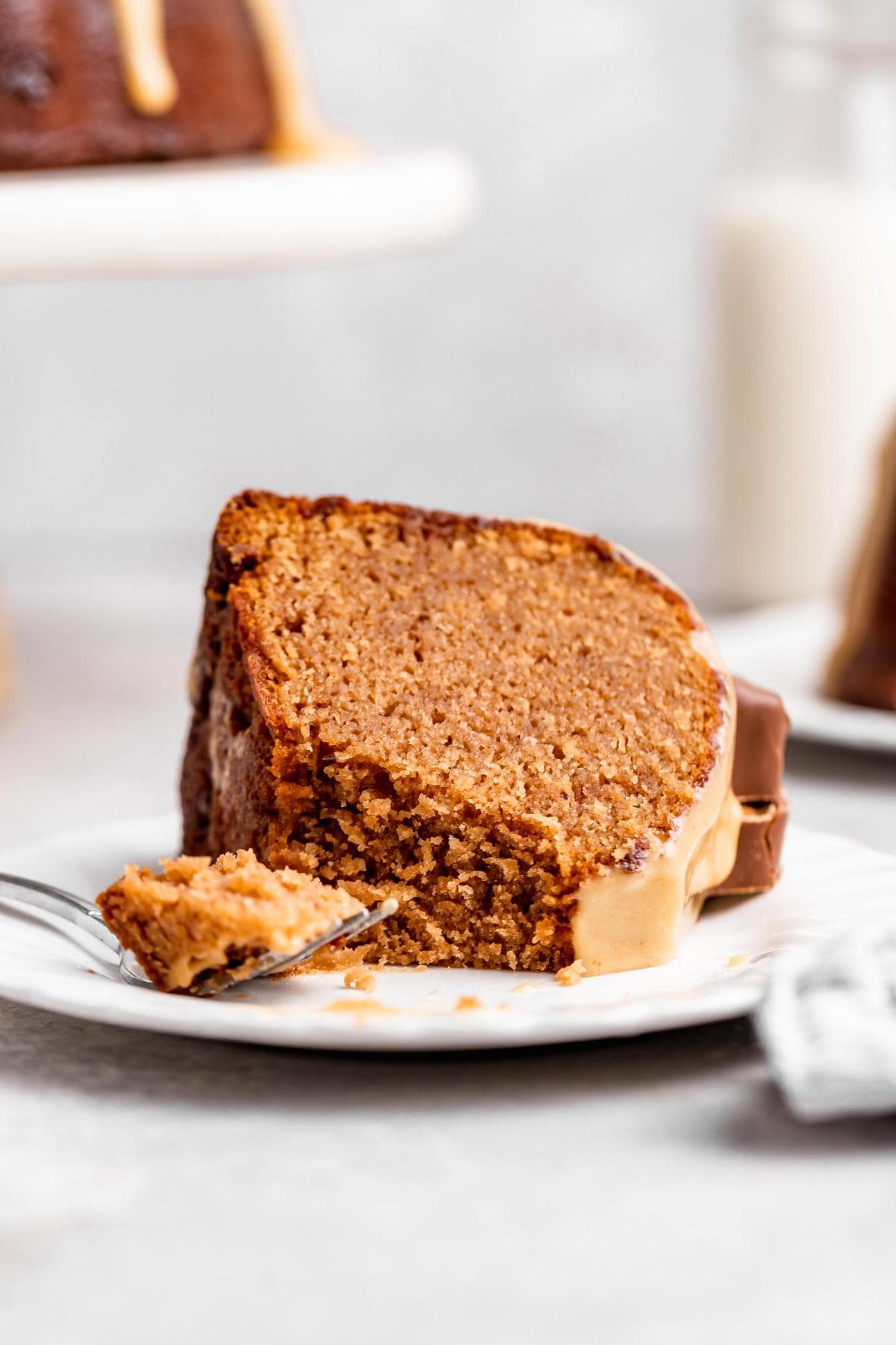 A slice of milky way cake on a white plate with a fork cut into it