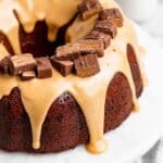 A close up of a milky way cake with a white chocolate glaze with cut up milky way bars