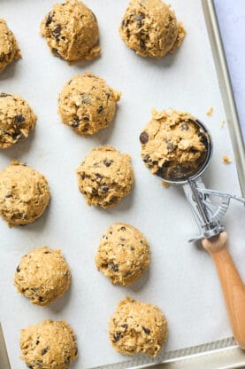 Cookie dough scooped on a parchment lined baking sheet