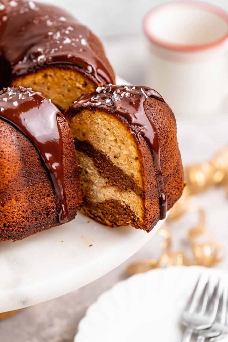 A slice of chocolate marble cake with sweet potato batter being pulled out after being cut