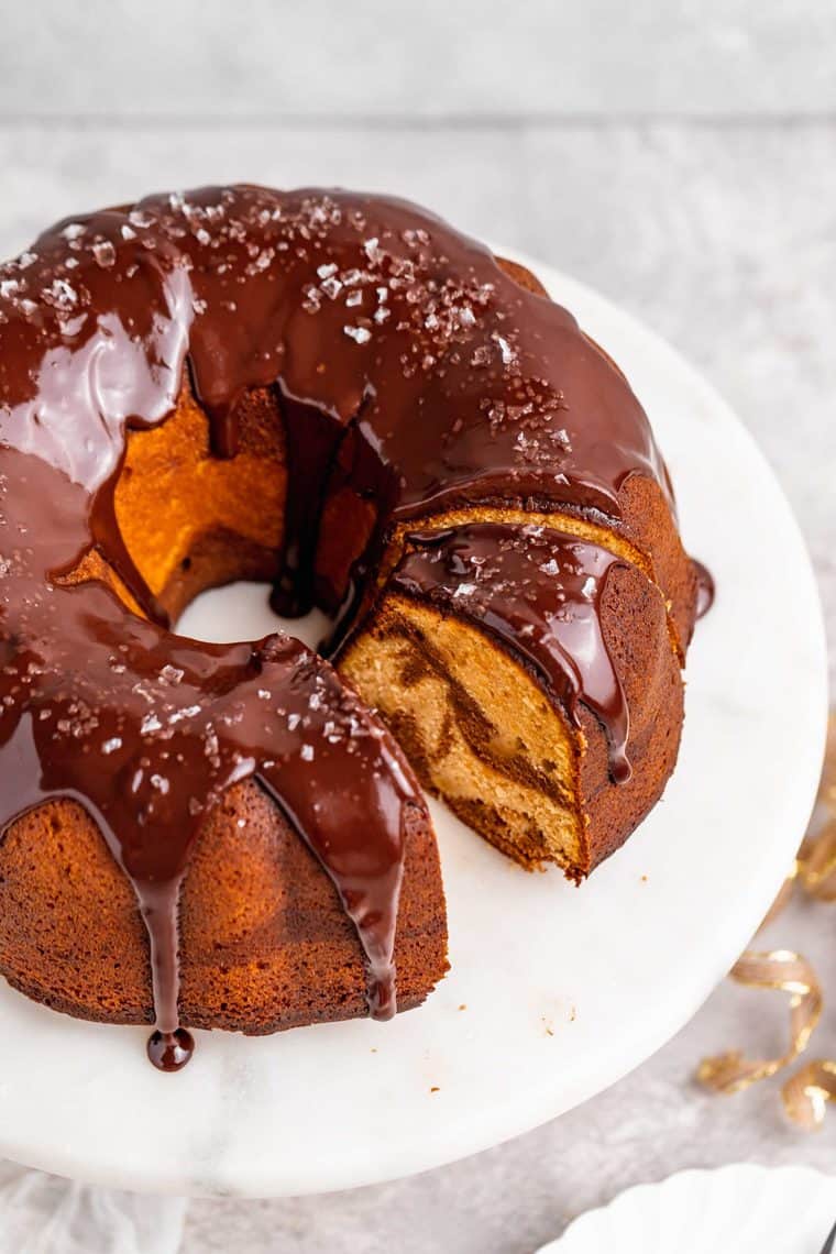 An overhead of a marble bundt cake with a slice cut