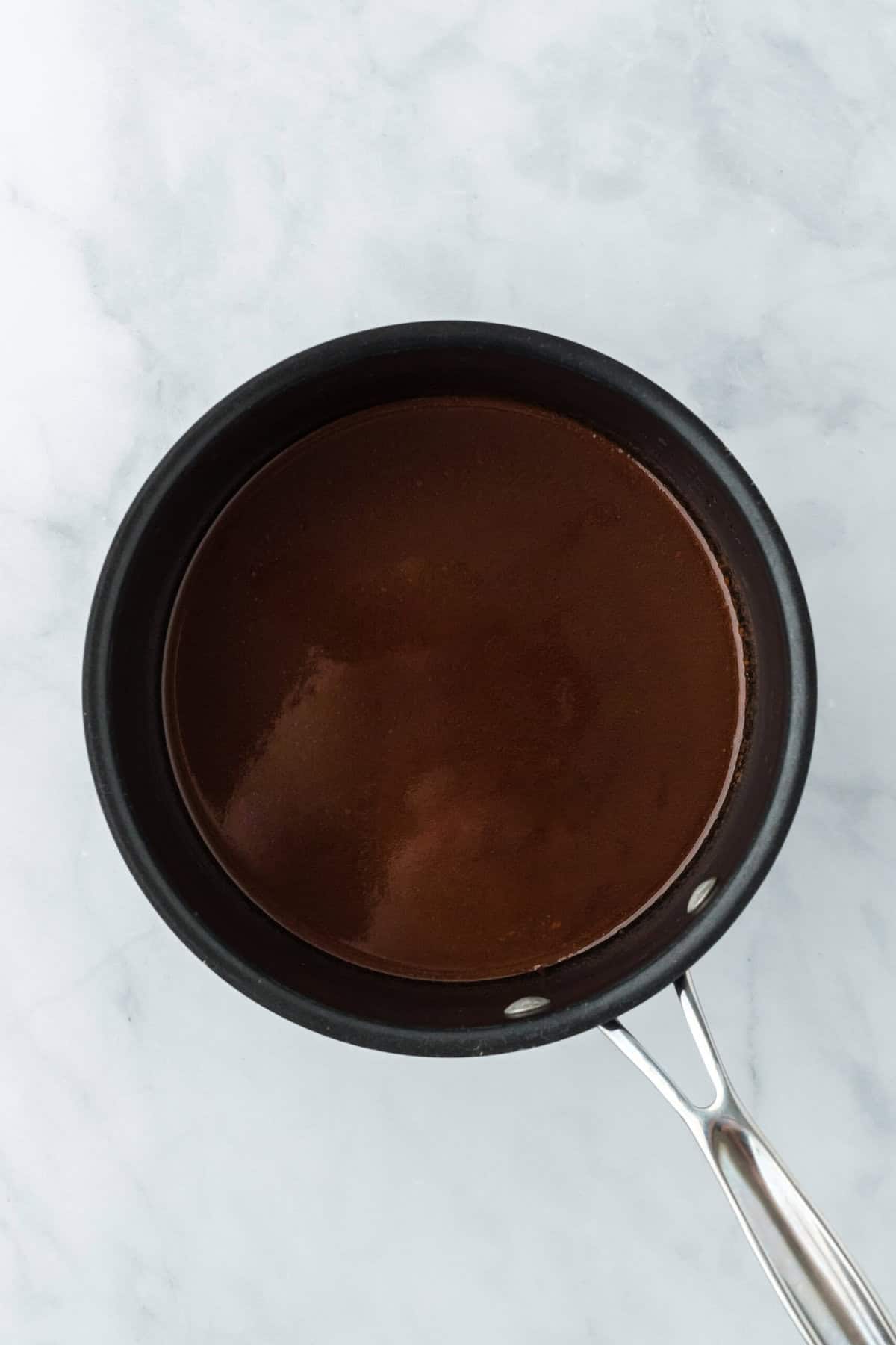 Melted chocolate sauce in a pot on white countertop