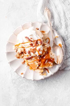 A slice of punchbowl cake on a white plate ready to serve with a spoon