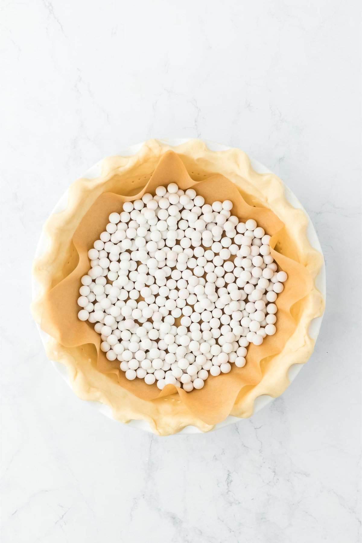 Overhead shot of a pie crust filled with pie weights