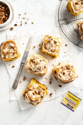 Cinnamon rolls scattered on the parchment paper on a white background