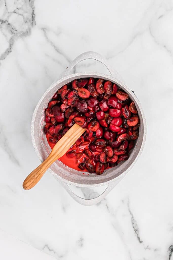 Cherries added to filling in a pan to cook down.