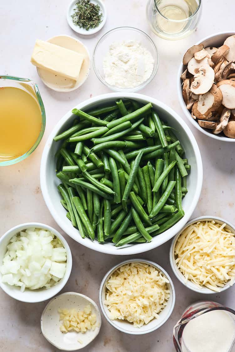 Green beans, cheese, onions and other ingredients against a plain background before cooking