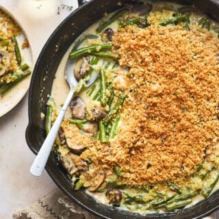 A delicious crispy garlicky green bean casserole with a spoon serving some