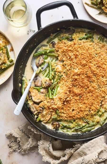 A delicious crispy garlicky green bean casserole with a spoon serving some