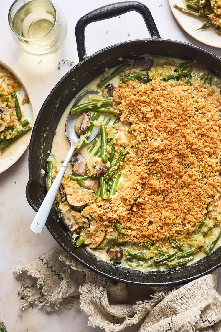 A delicious crispy garlicky green bean casserole with a spoon serving some