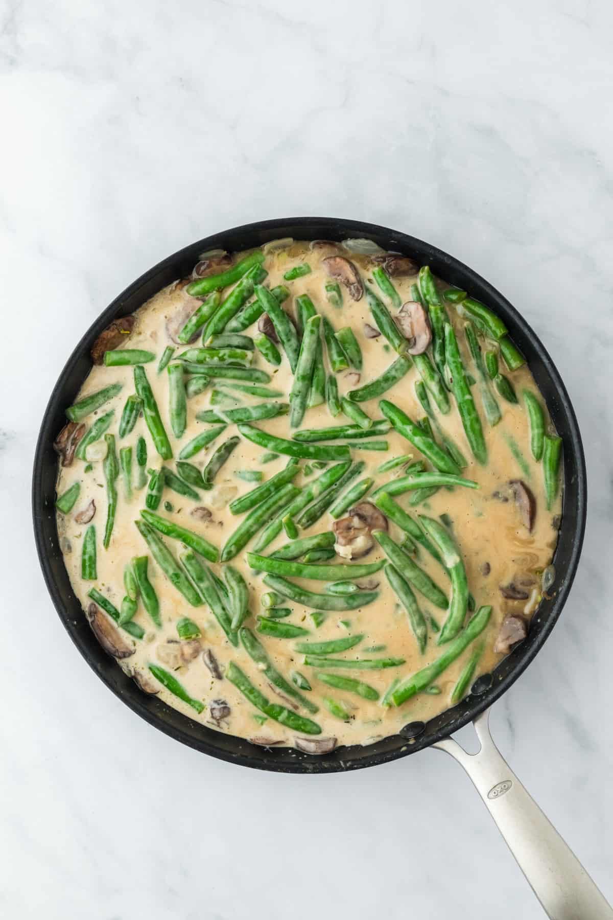 Creamy bean casserole from scratch before baking in skillet