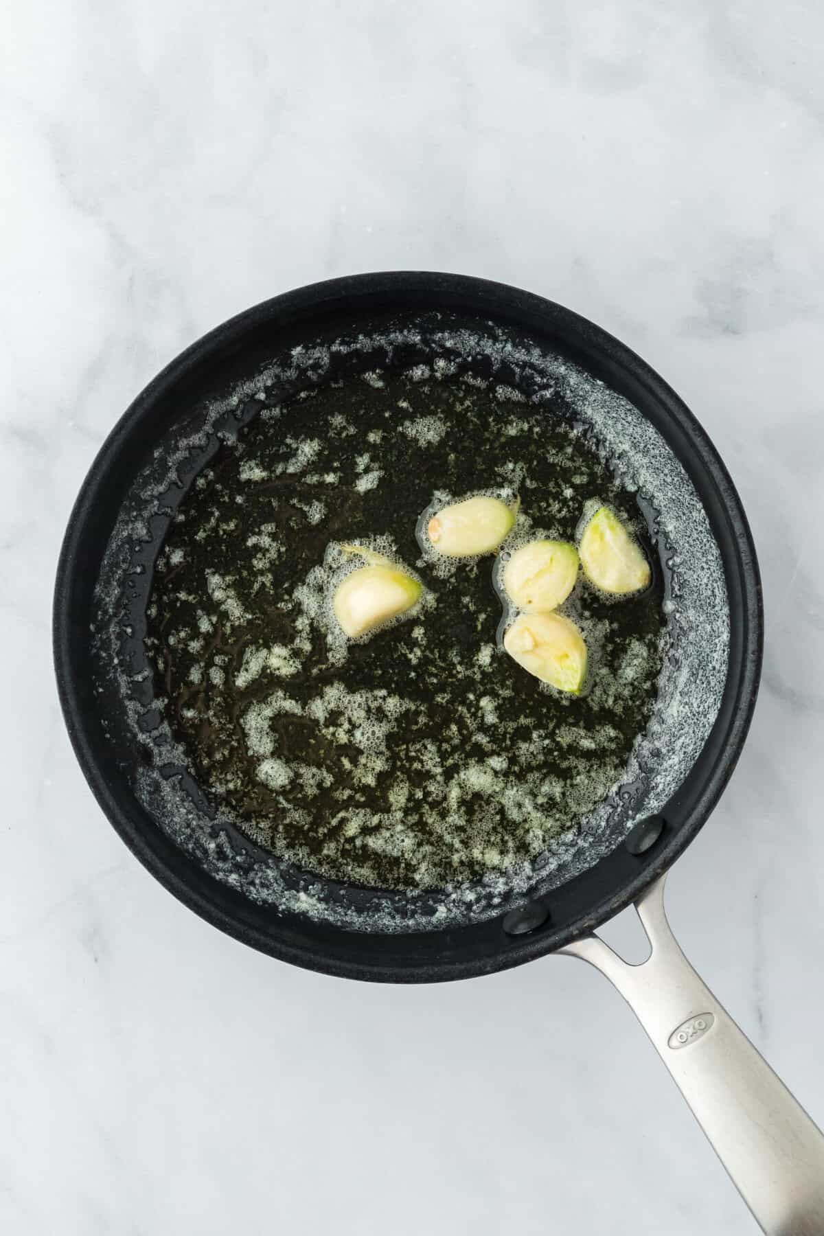 Butter and garlic cloves in a skillet cooking