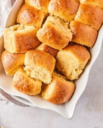 A close up of dinner rolls pulled part in a white casserole dish