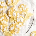 Lemon crinkle cookies on a wire rack under parchment paper