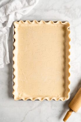 A long pie dough rolled out into a sheet pan