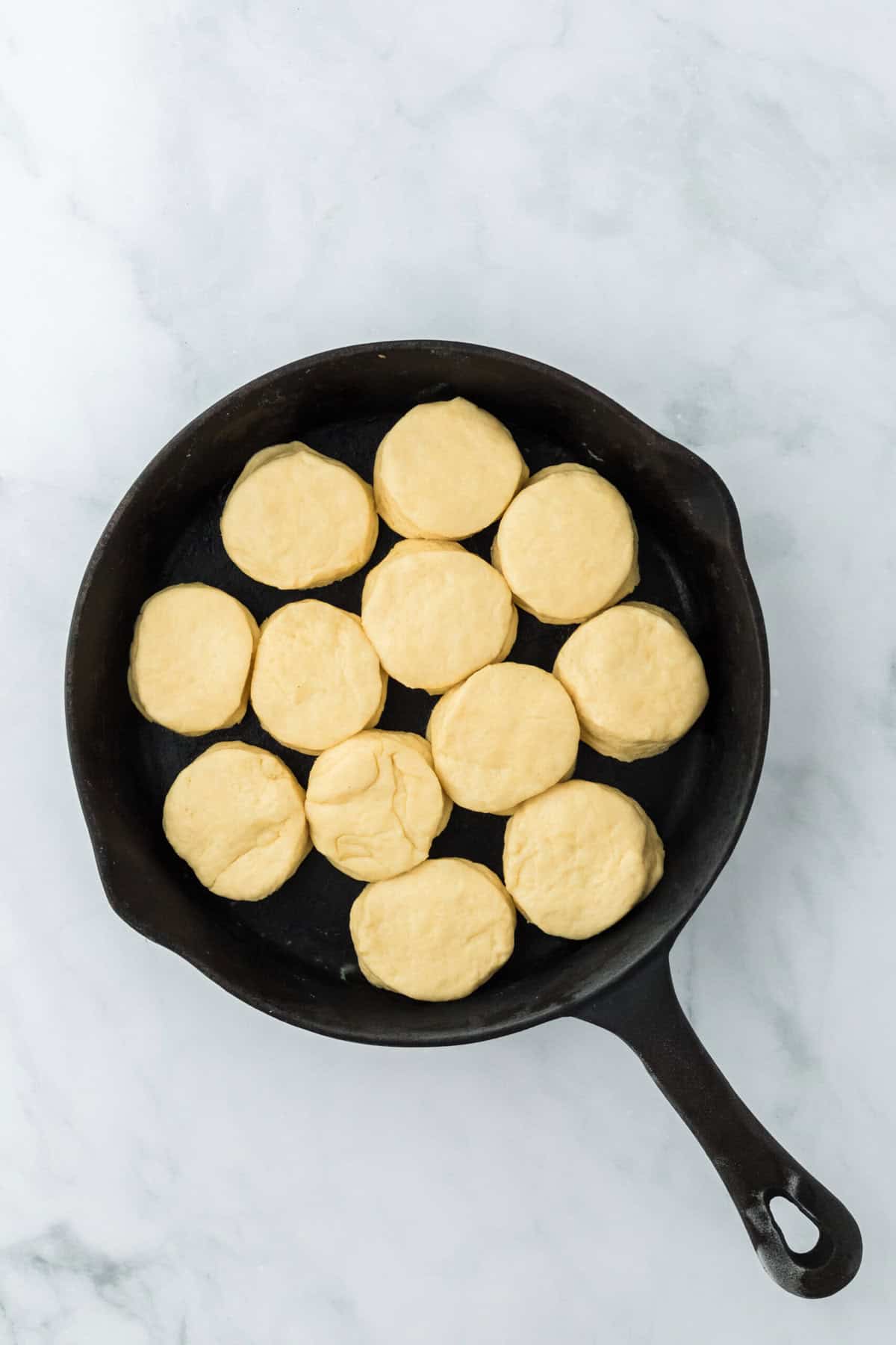 Biscuit dough rounds in cast iron skillet after rising