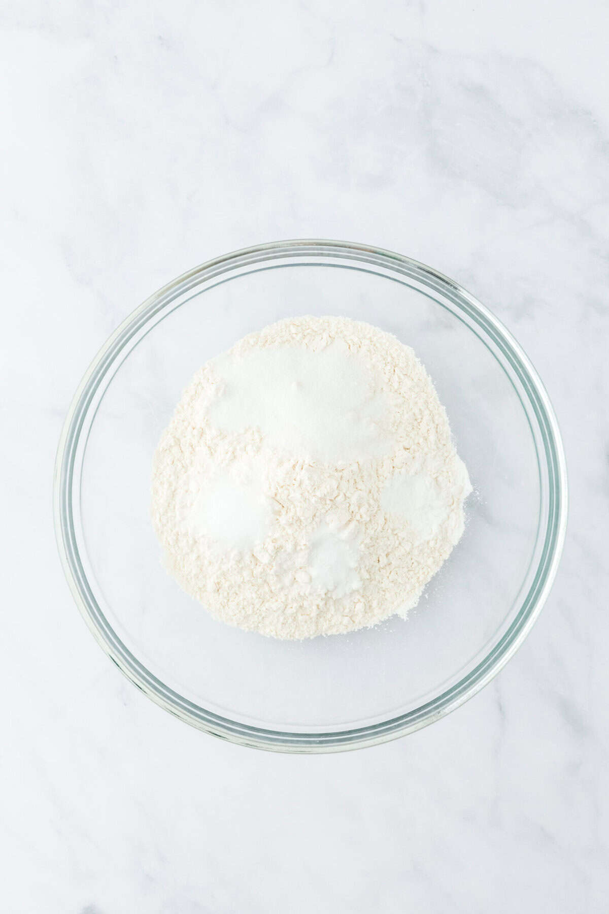 Dry ingredients in a glass bowl on a white countertop