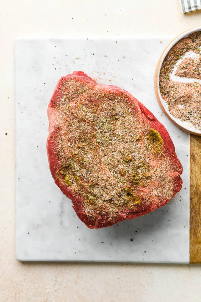 A seasoning rub spread over the top of a chuck roast