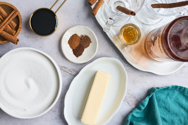 Butter, spices, rum and cinnamon sticks out as ingredients for making a recipe