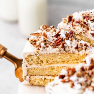 A slice of yellow Italian cake coming out of a layered cake