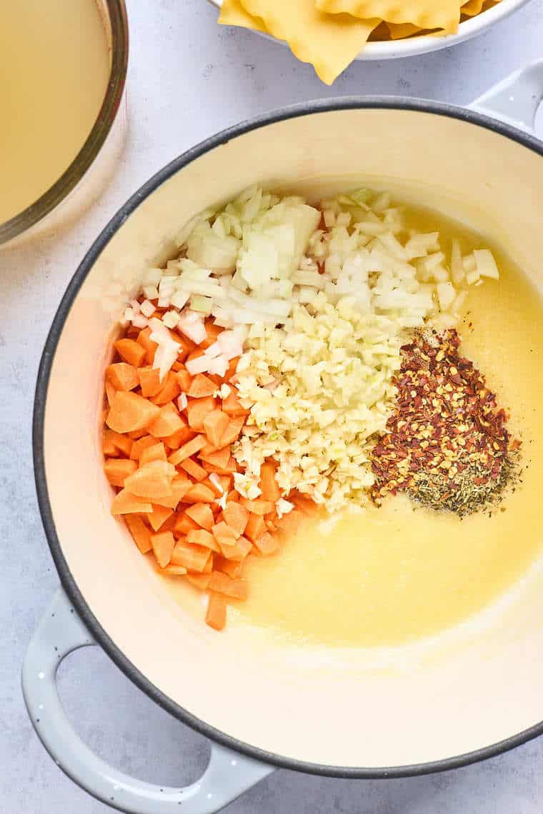 Carrots, onions and butter simmering in a large dutch oven